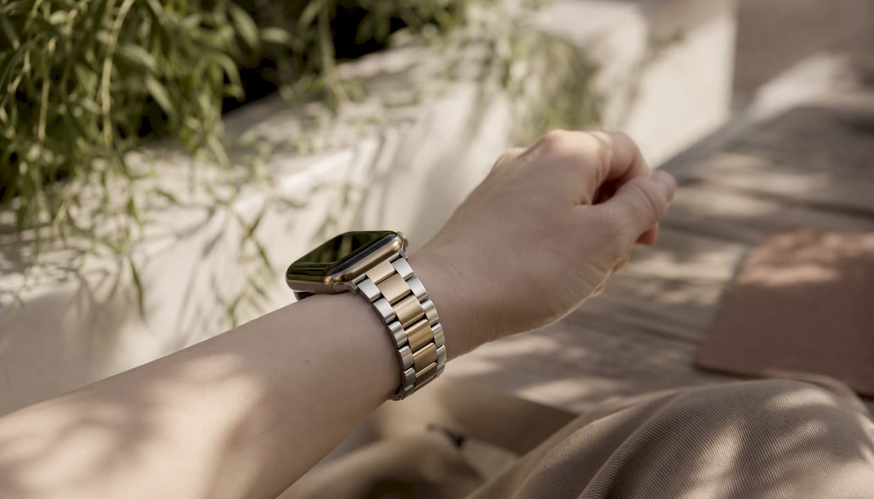 Wrist with pale champagne and two-tone bracelet on cool undertone