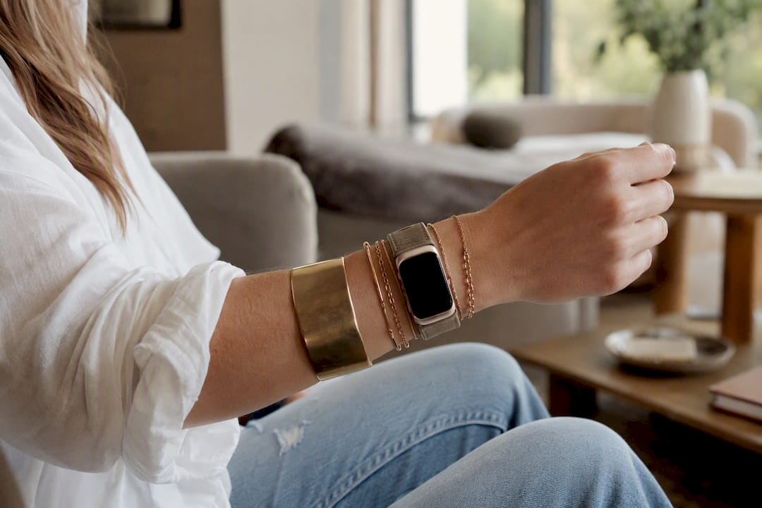 Wrist with chunky and delicate bracelets paired with watch