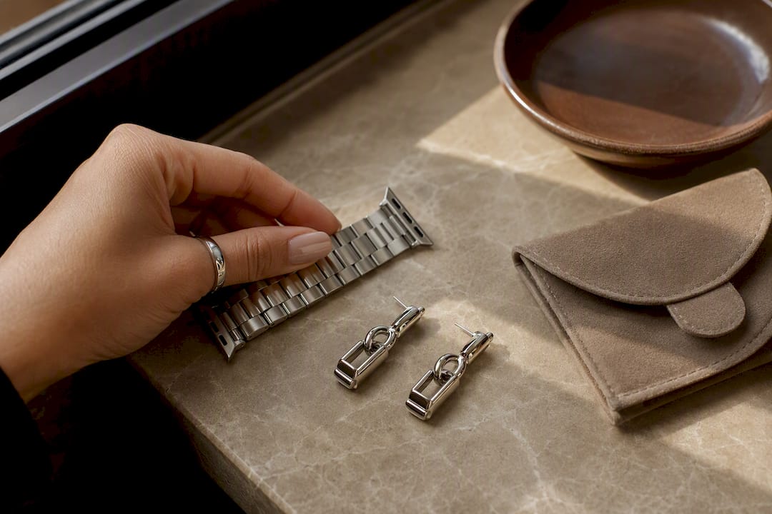 Hand comparing watch band and earrings
