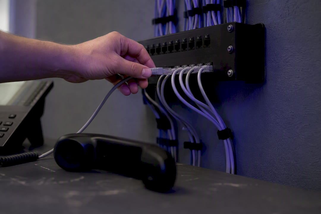 Hand plugging network cable near telephone handset