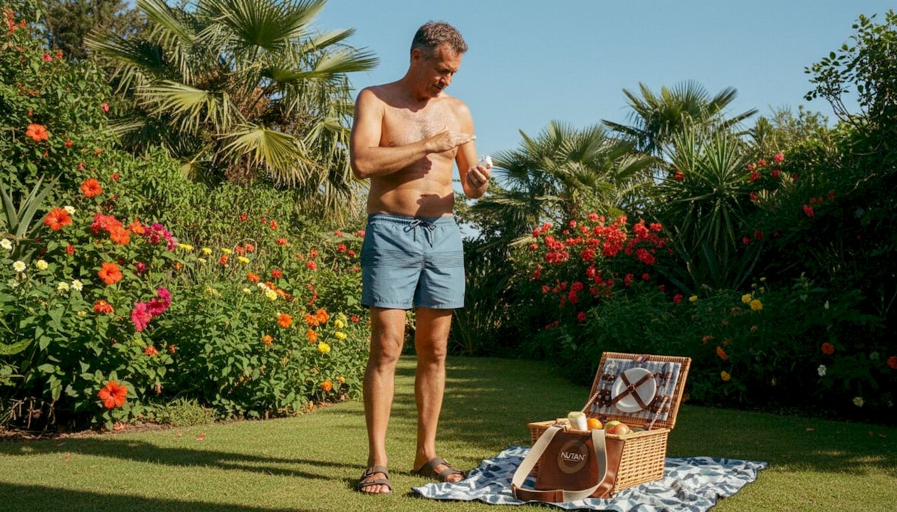 Man applying tanning accelerator on beach outdoors