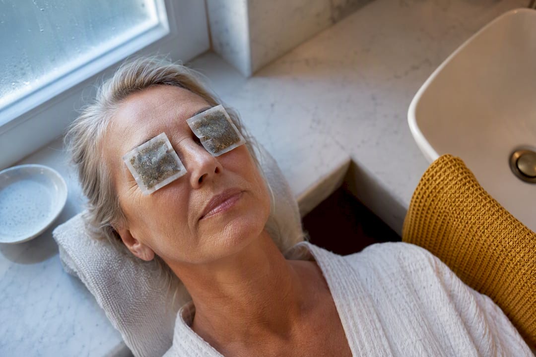 Chilled tea bags placed over closed eyes