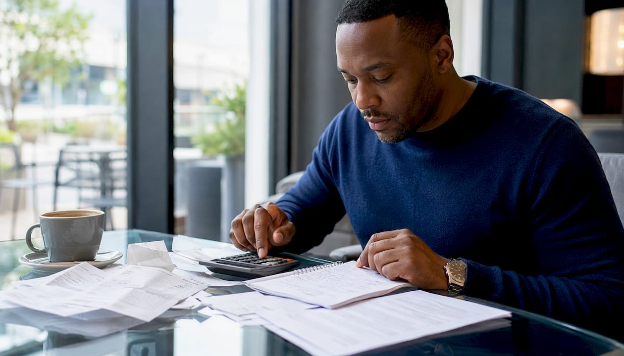 Hands calculating car accident bills on desk