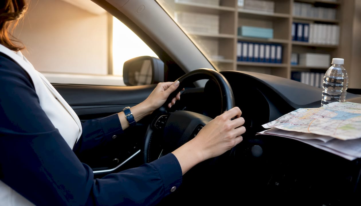 Manos al volante, con los papeles del seguro y algunas notas a mano