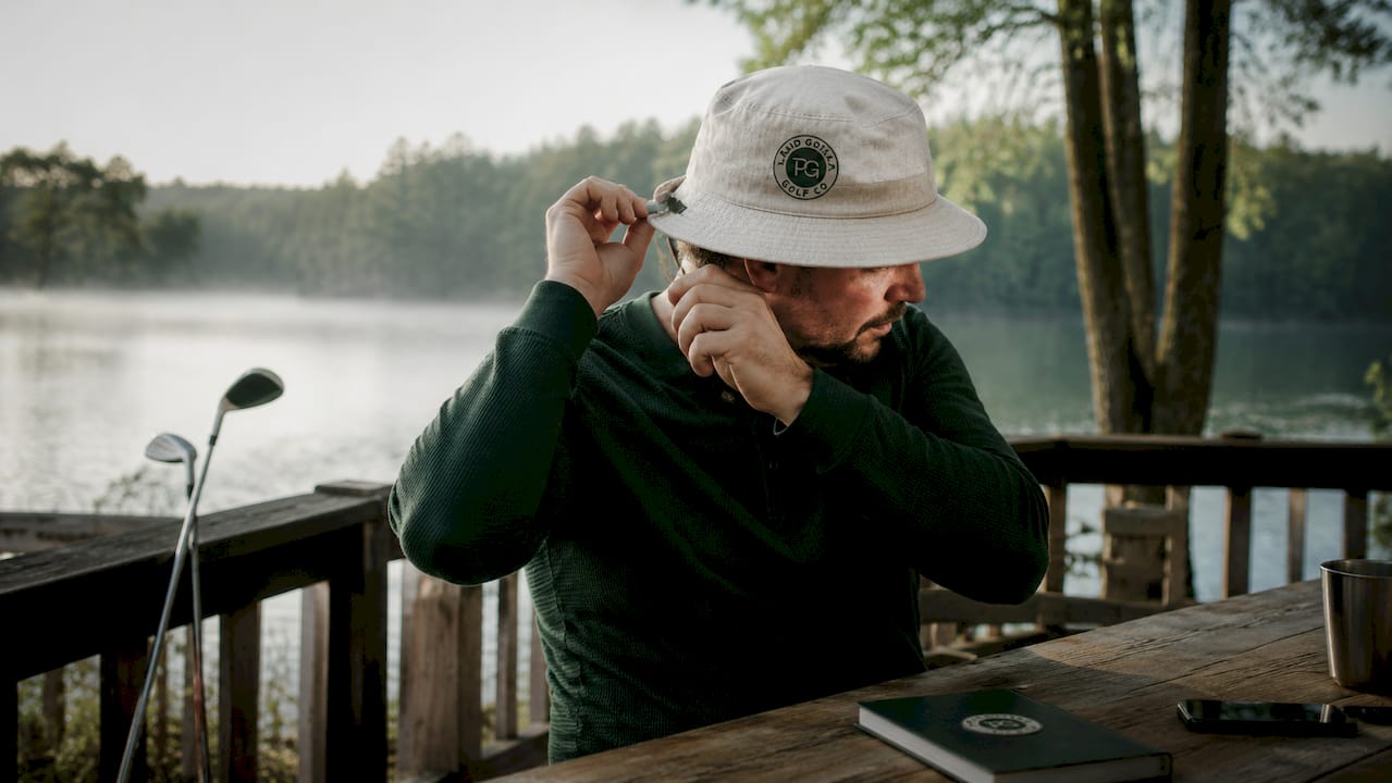 Hands adjusting oversized golf hat strap outdoors