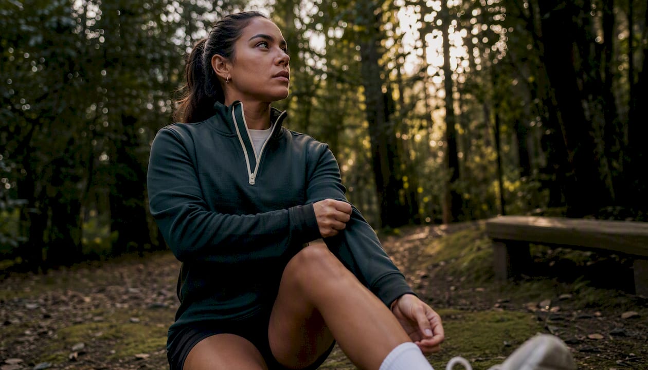 Athlete outdoors adjusting quarter-zip hoodie