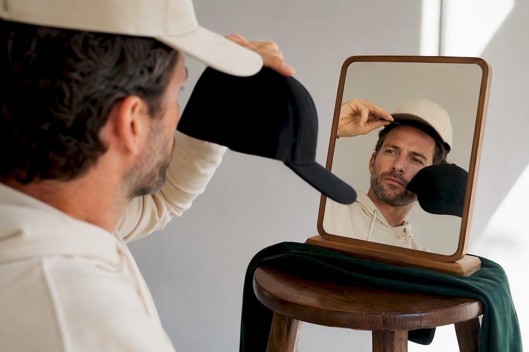 Golfer checking brim proportions in mirror