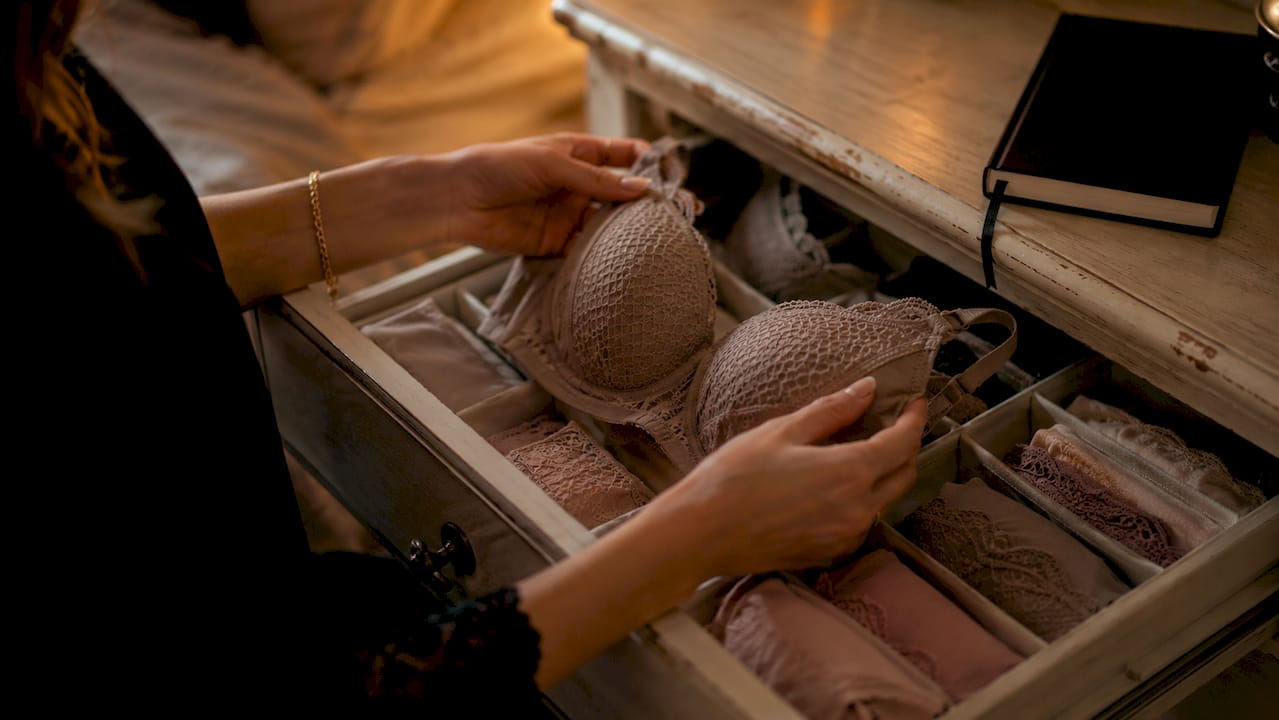 Hands selecting neutral tone lingerie