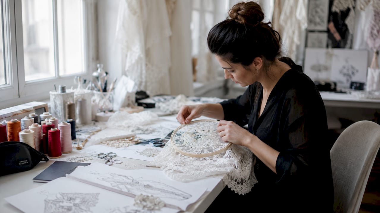 Hands working on delicate Chantilly floral lace