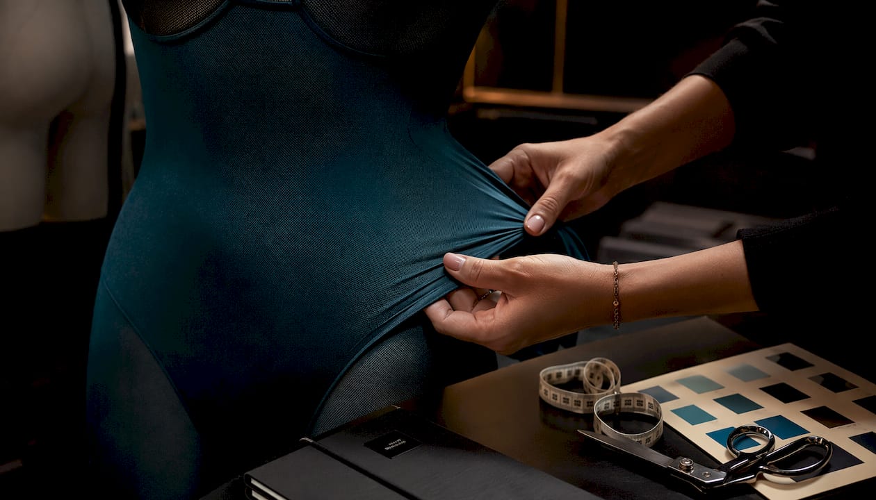 Hands inspecting sheer bodystocking fabric stretch