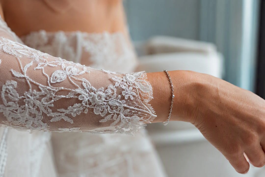 Silver bracelet on lace sleeve wrist