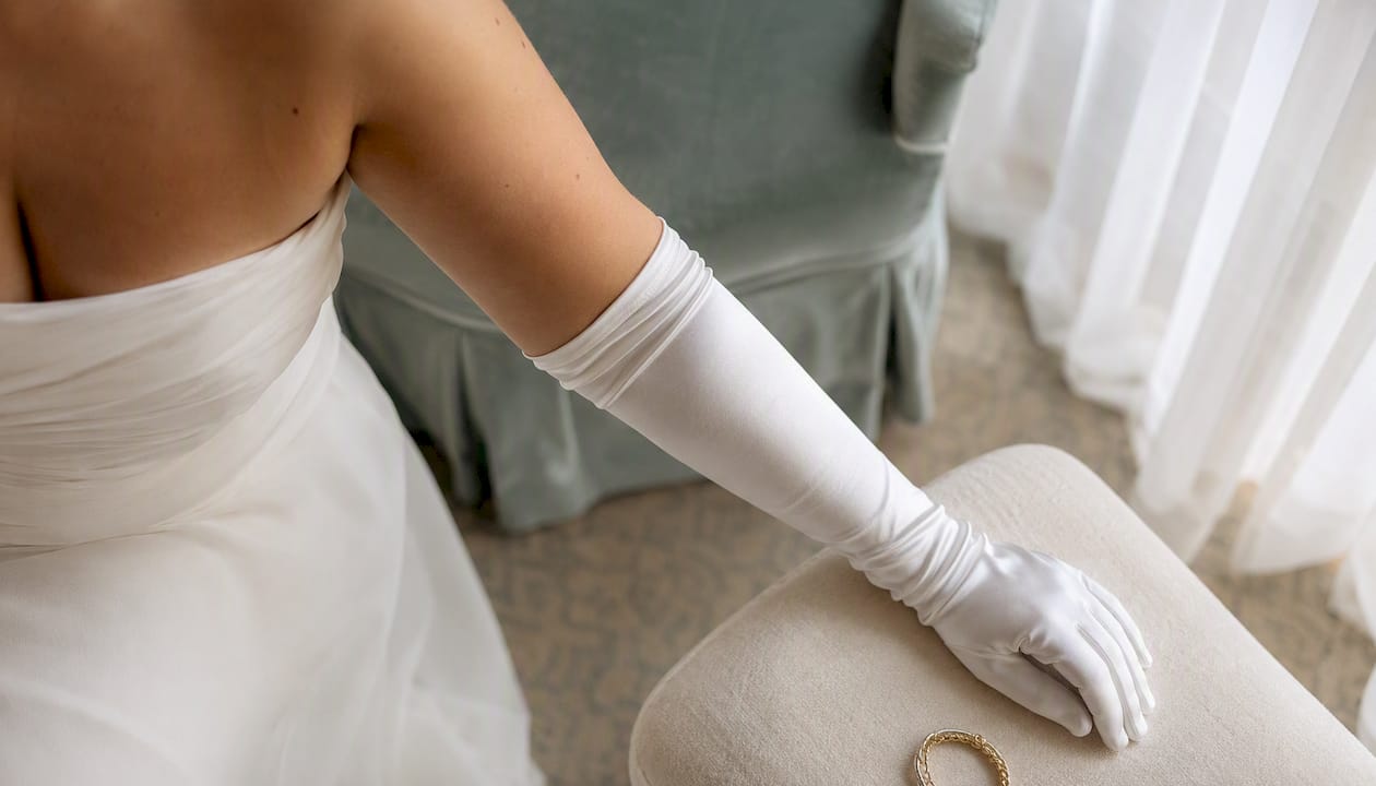 Curvy bride wearing satin elbow-length gloves