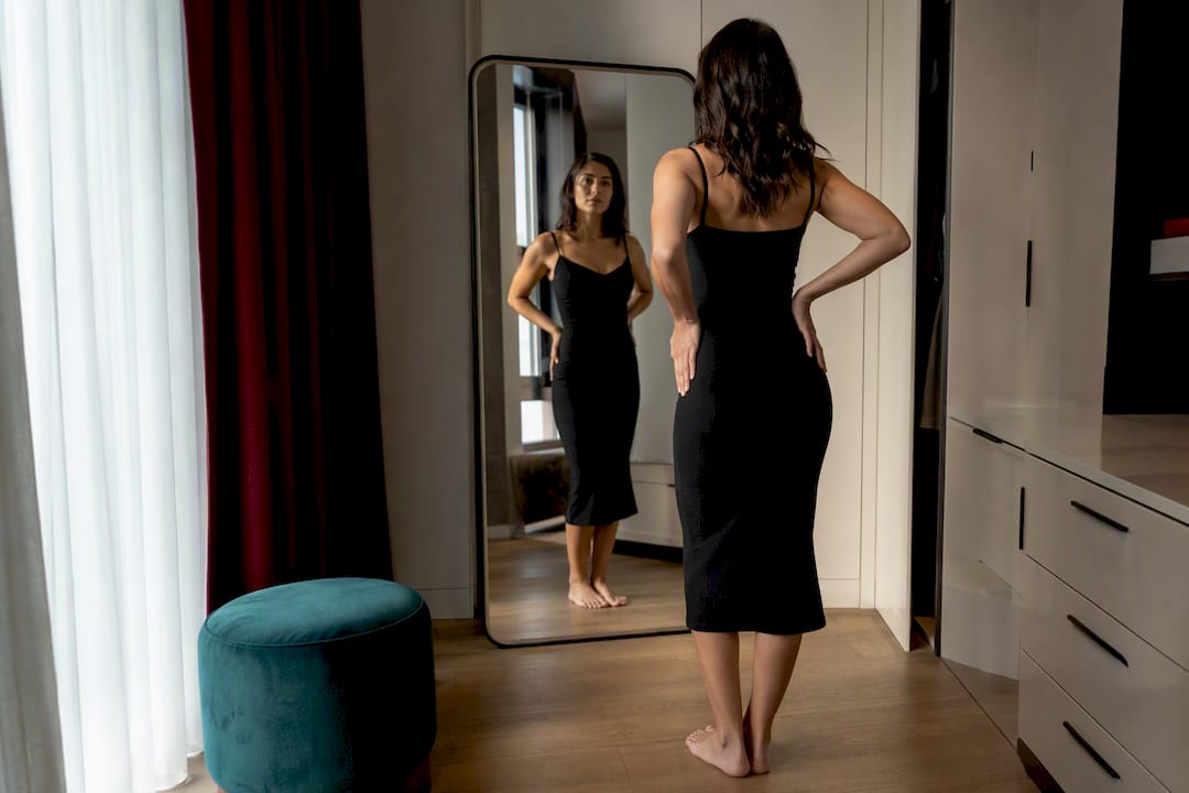 Woman checking fitted dress side profile