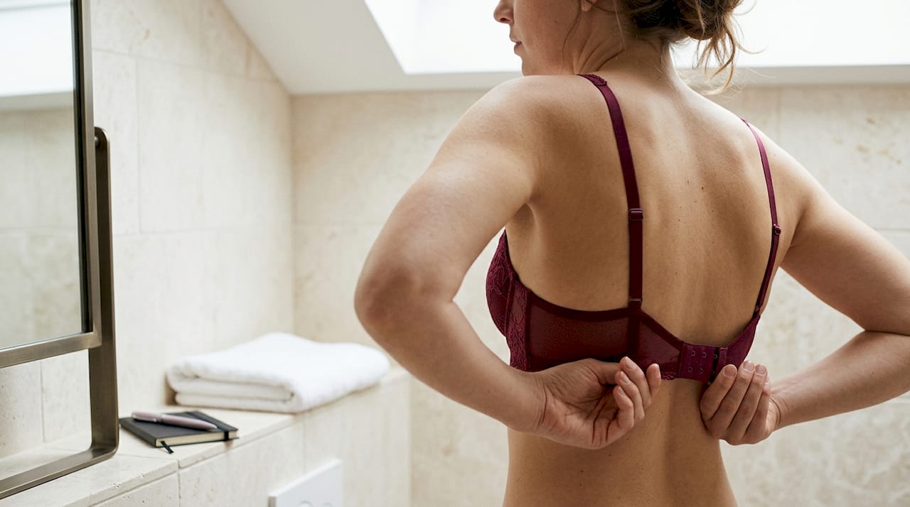 Woman performing lingerie hook test