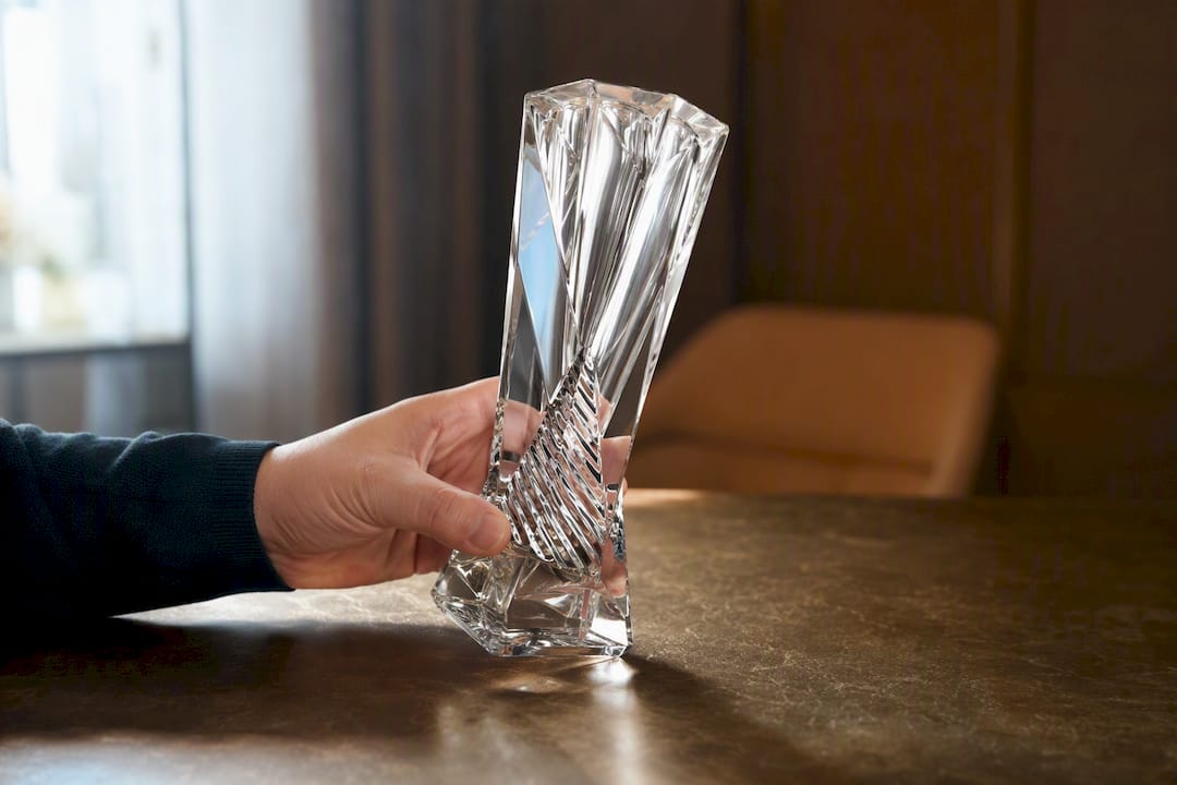 Kristallpreis mit Gravur, der in den Händen gedreht wird