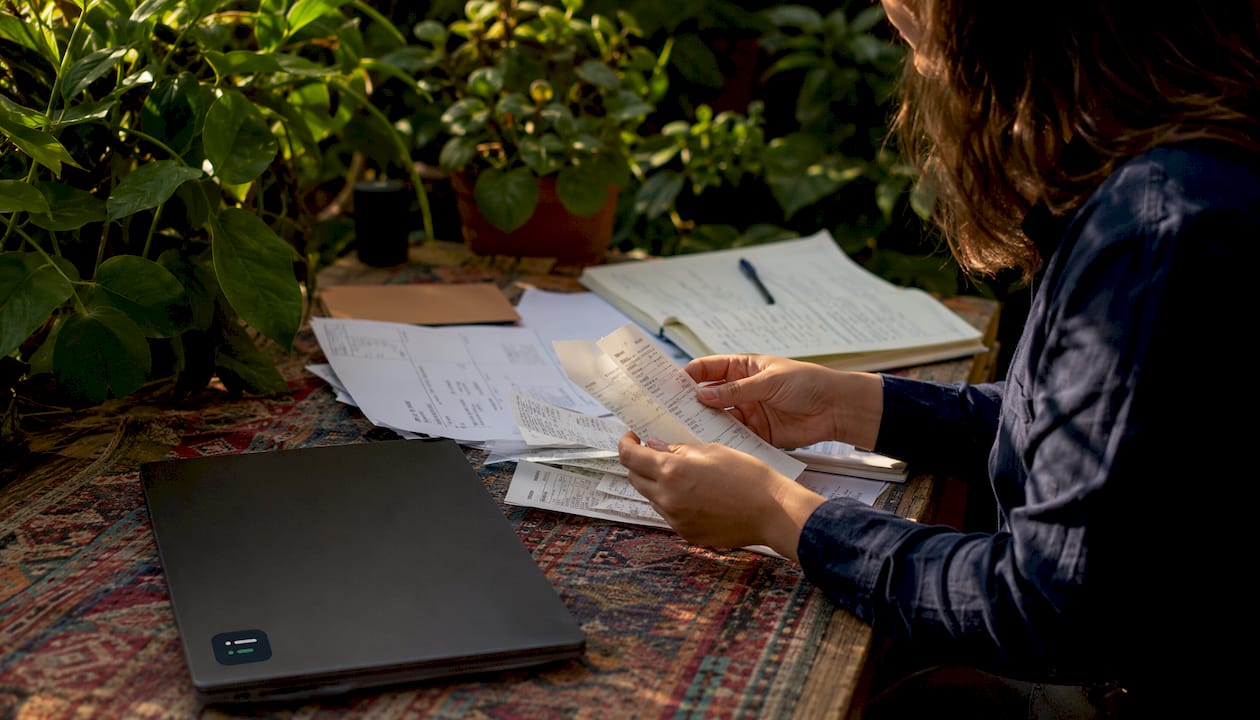 Hands sorting invoices and close checklists