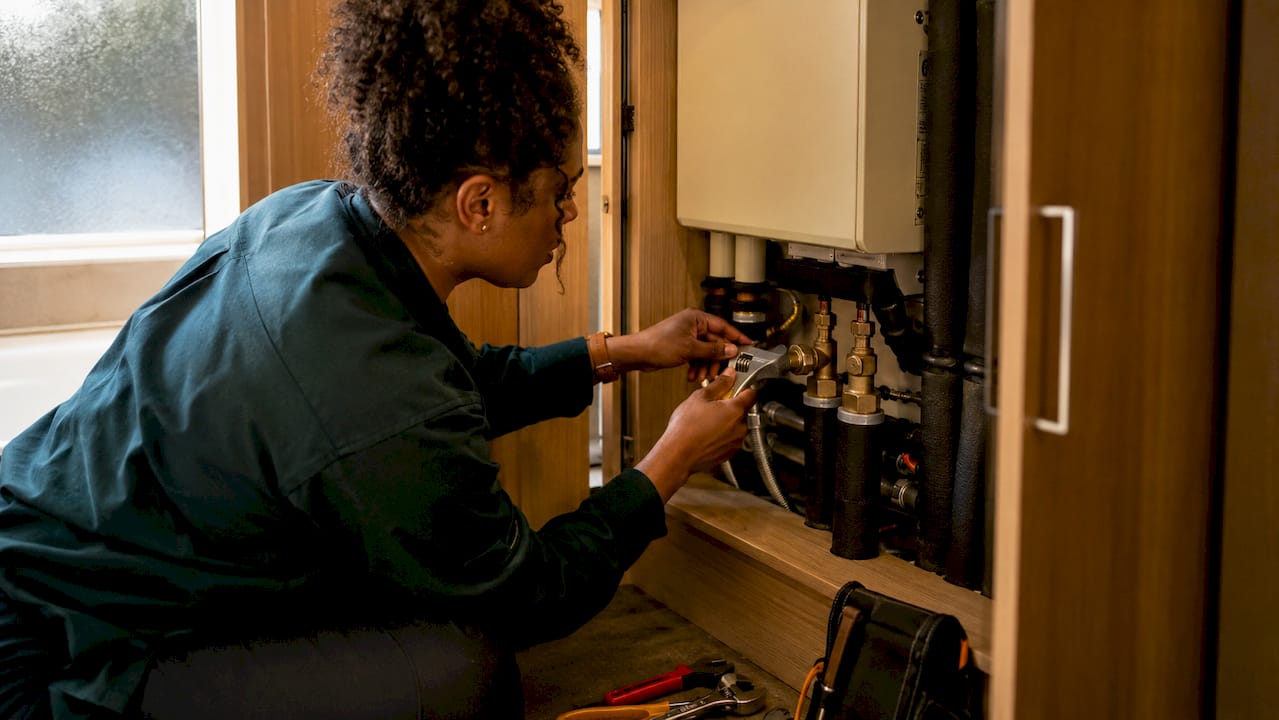Plumber installing heat interface unit in apartment