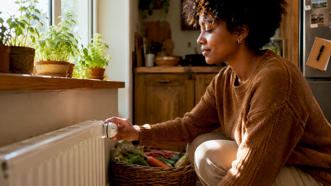 Person adjusting radiator temperature valve