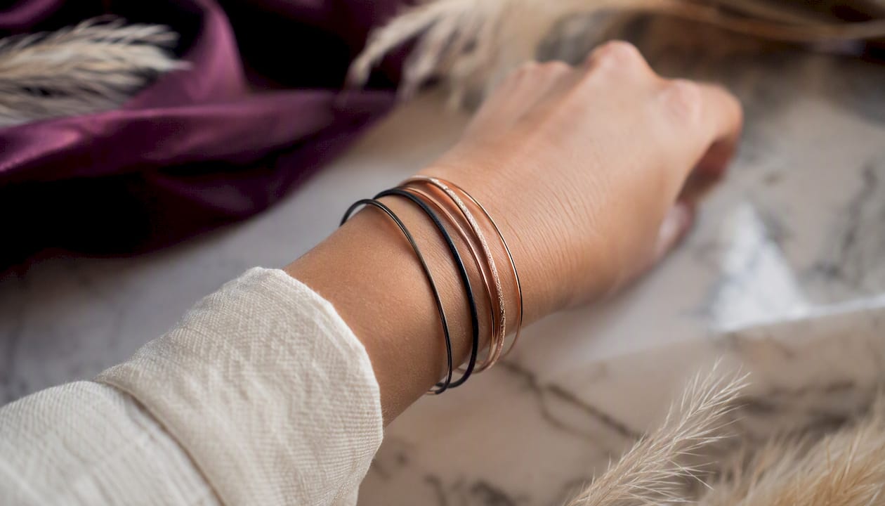 Stacked mixed metal bangles on wrist