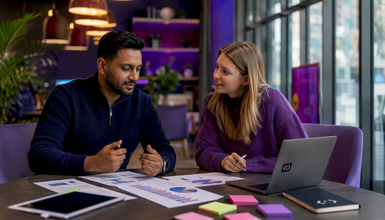 Hands pointing at marketing charts on table