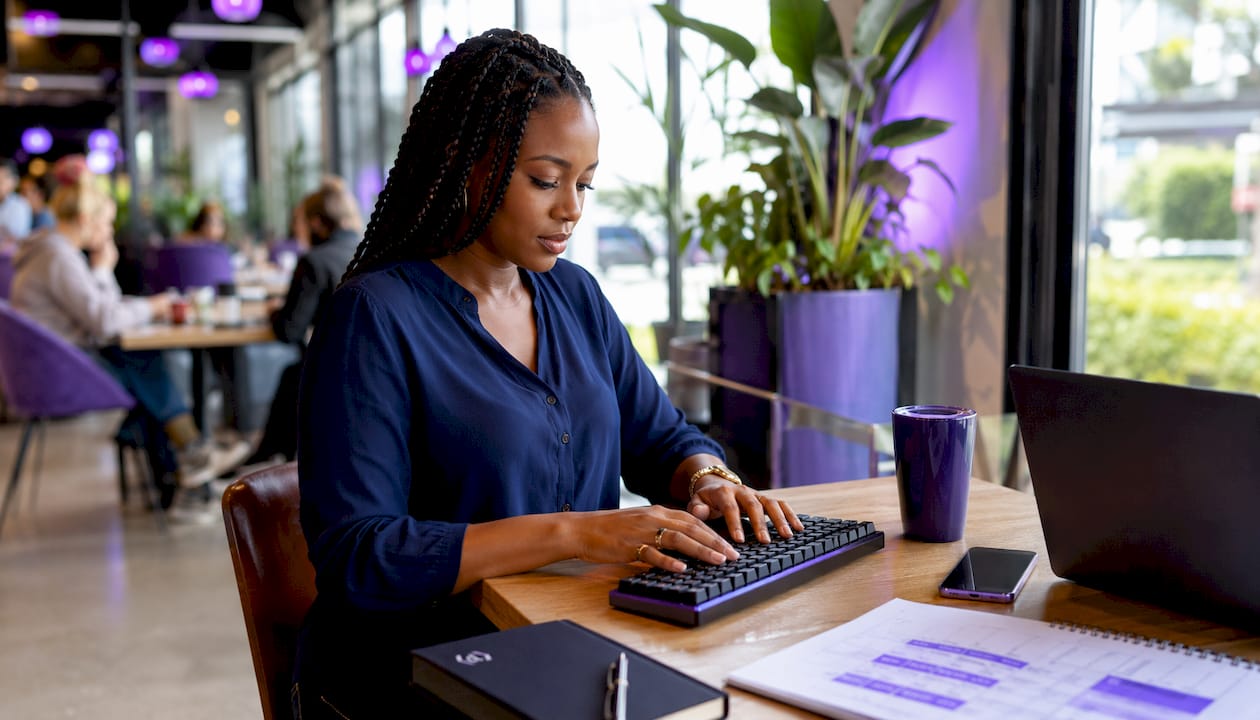 Hands typing near marketing audit checklist at home office