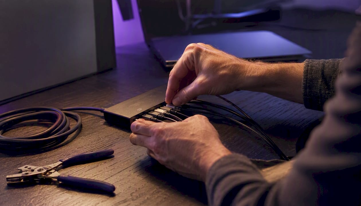 Hands wiring modem cables on tech desk
