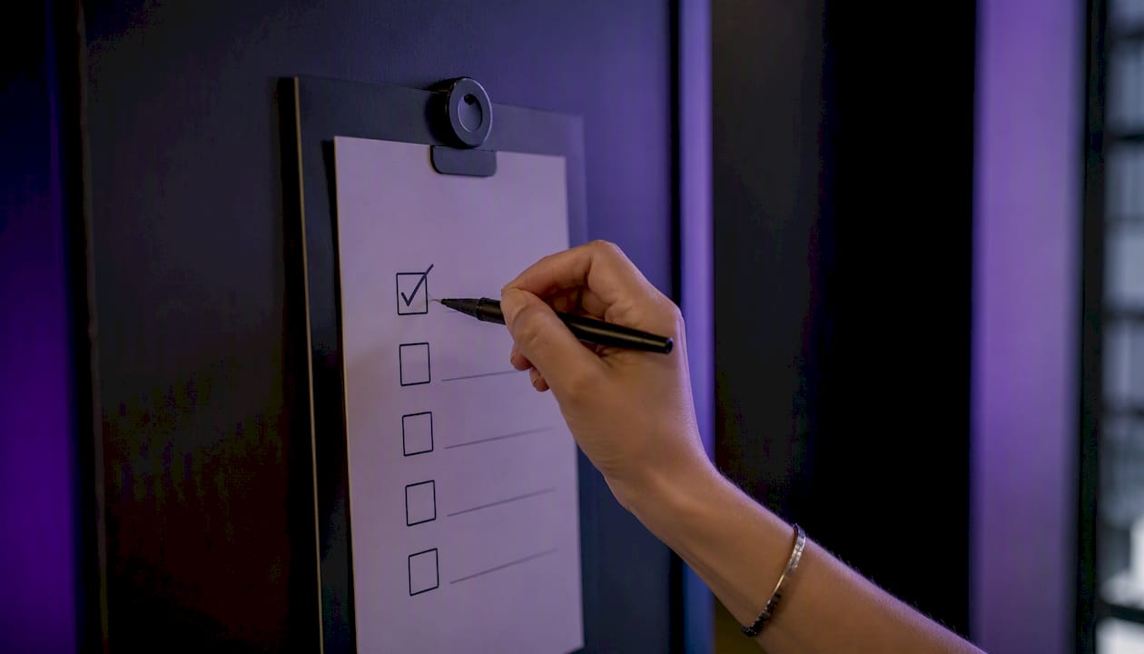 Hand ticking onboarding checklist box