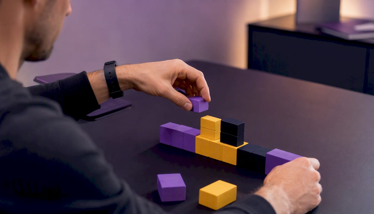 Hands arranging acrylic blocks labeled site categories