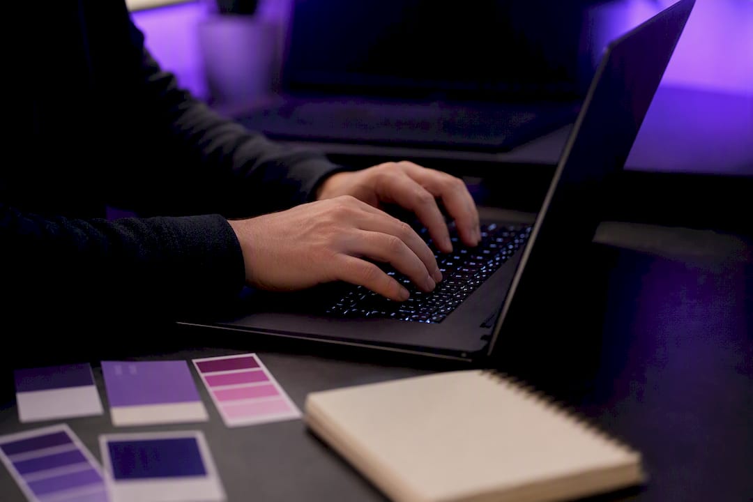 Developer coding design tokens on laptop keyboard