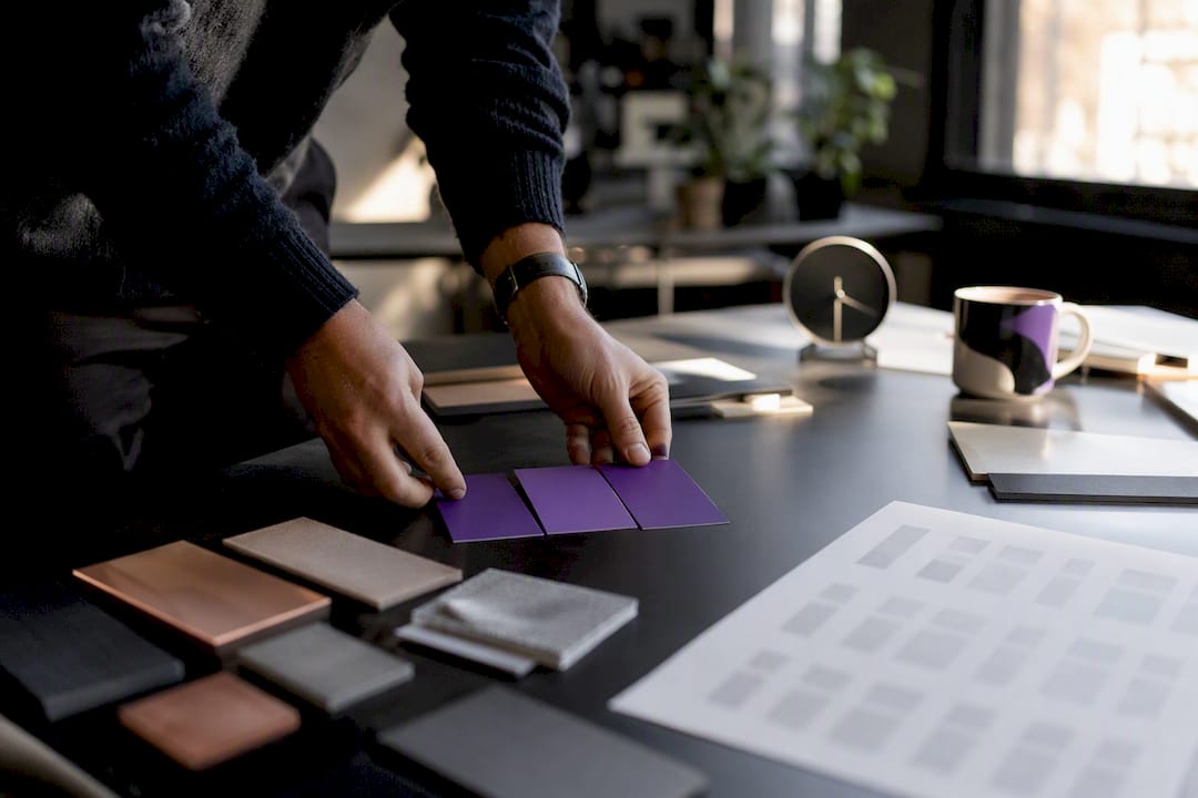 Hands arranging color swatches and font sheets