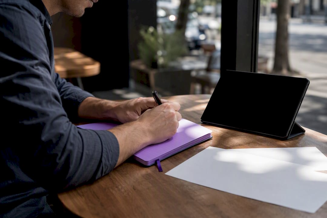 Hands writing SEO titles on notepad