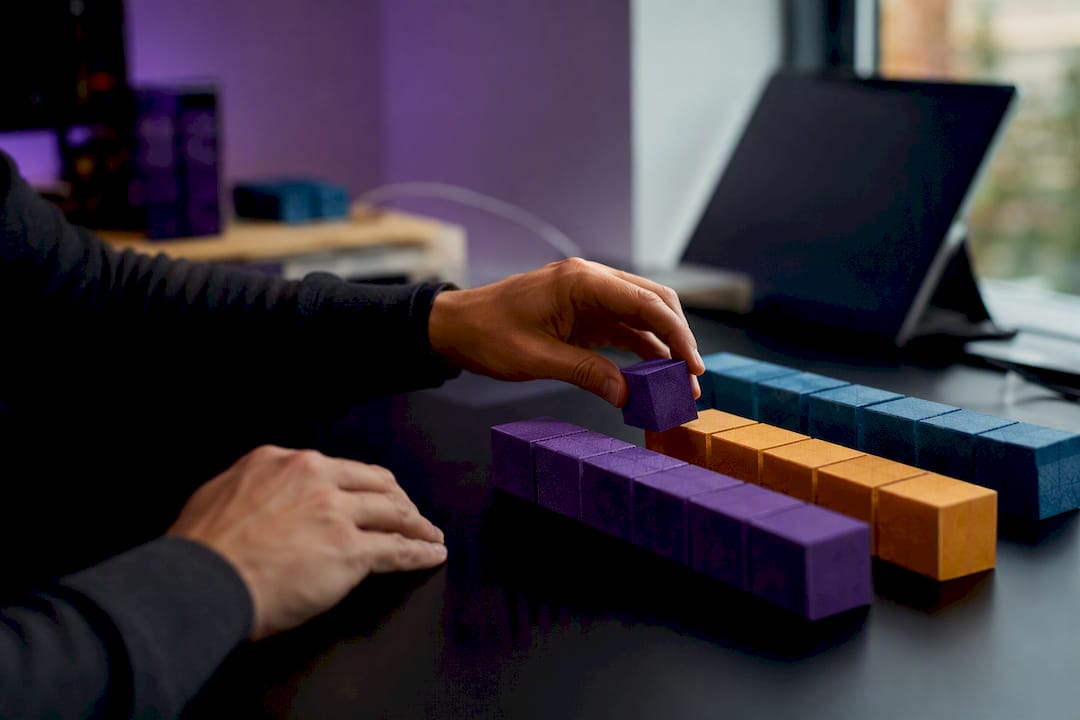 Hands building campaign name from color-coded blocks