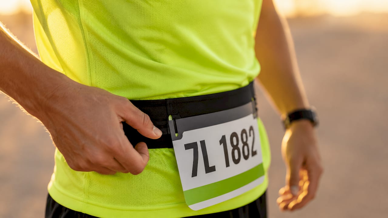 Close-up of race belt bib attachment on runner