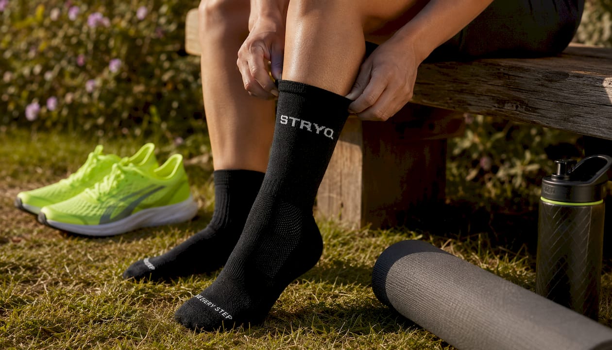 Athlete putting on merino wool running socks indoors