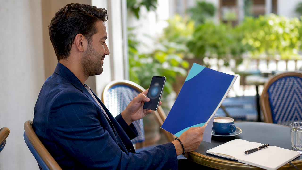 Hands holding certification and digital badge on phone