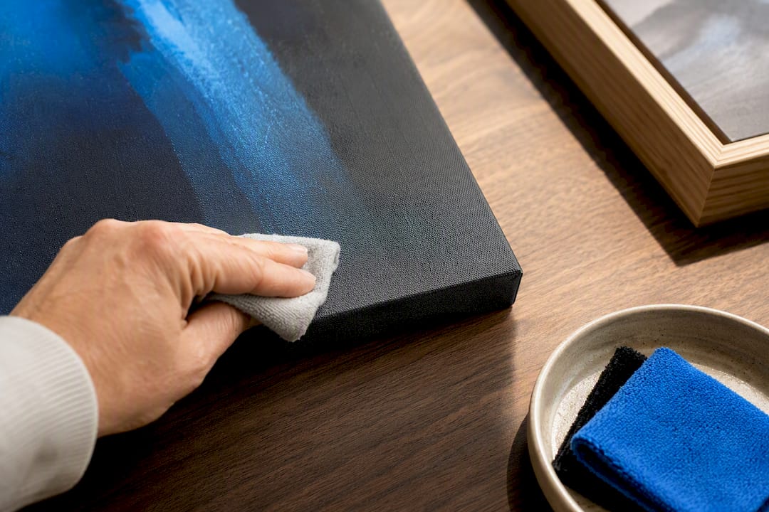 Microfiber cloth cleaning a canvas artwork