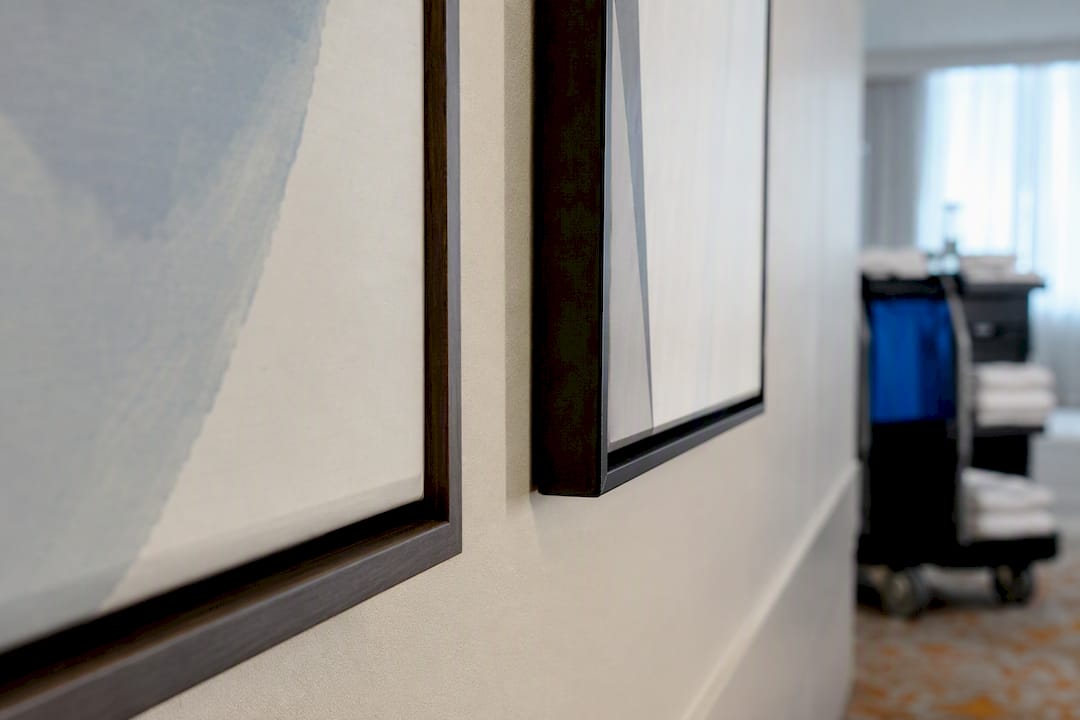 Hotel artwork frame depths beside housekeeping cart