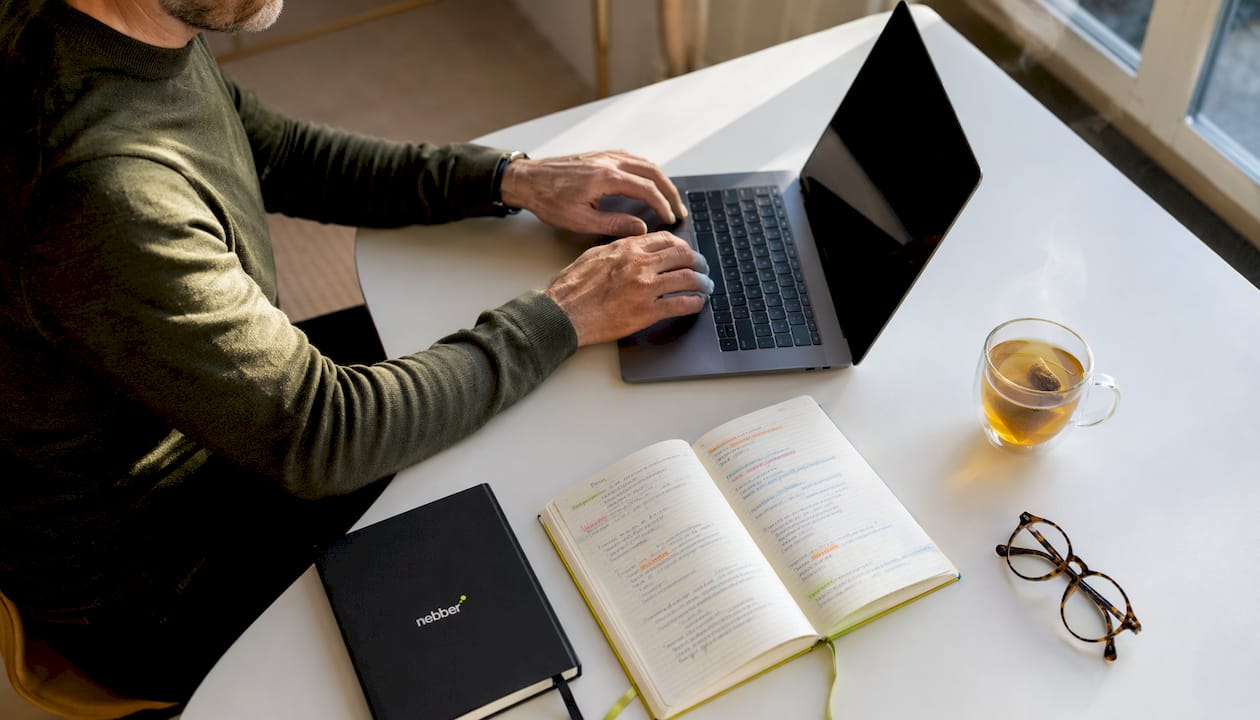 Iemand tikt aan een bureau thuis SEO-teksten op zijn laptop.