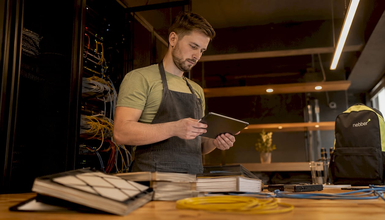 Een systeembeheerder loopt door de serverruimte om te controleren of alle servers goed draaien.