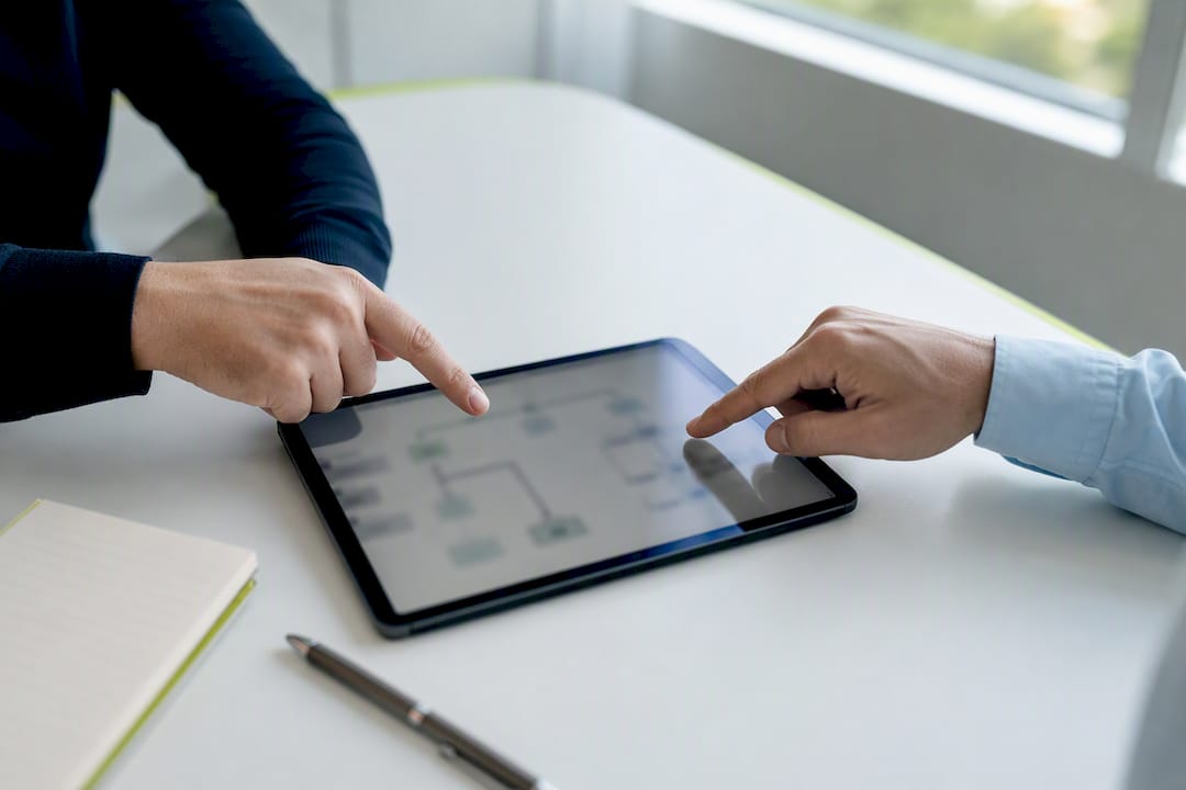 Handen die op een sitemap op een touchscreen wijzen
