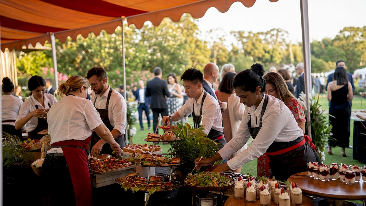 Catering staff setting up food stations