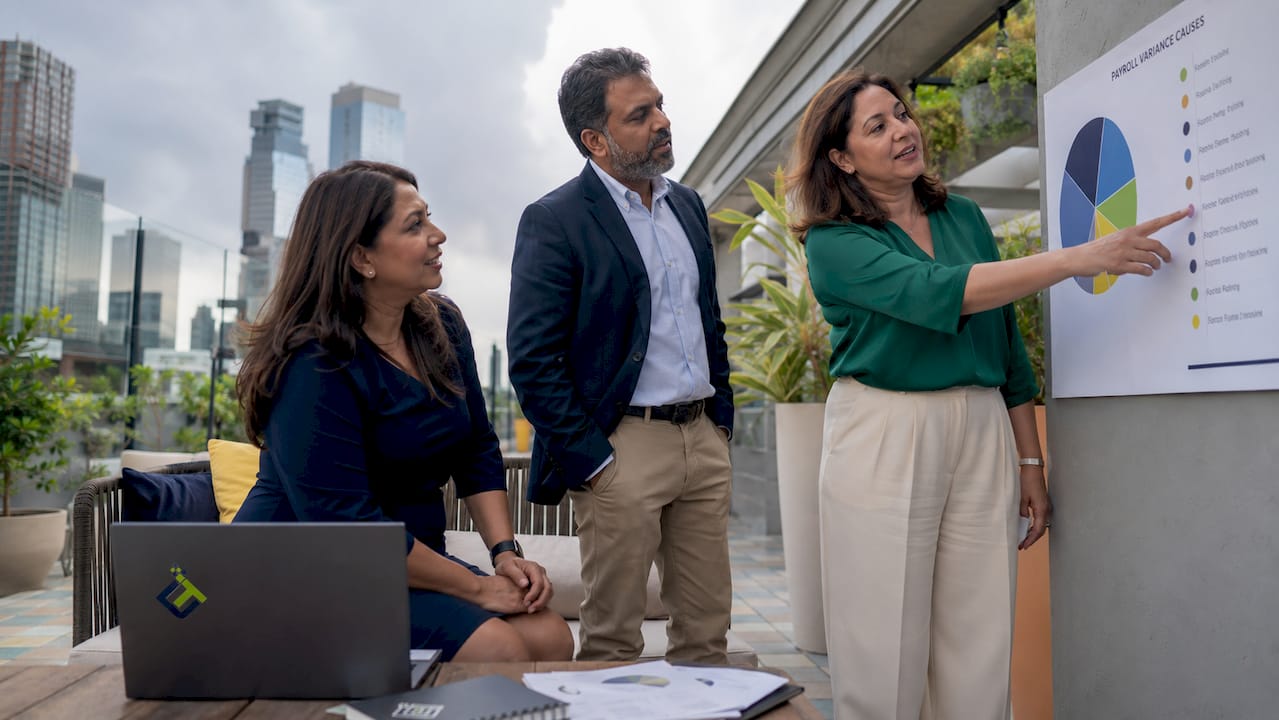Team discussing payroll variance causes in meeting room