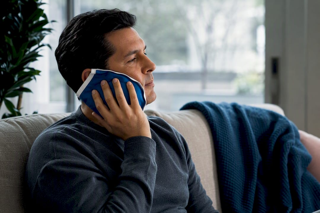 Adult applying cold compress for jaw pain