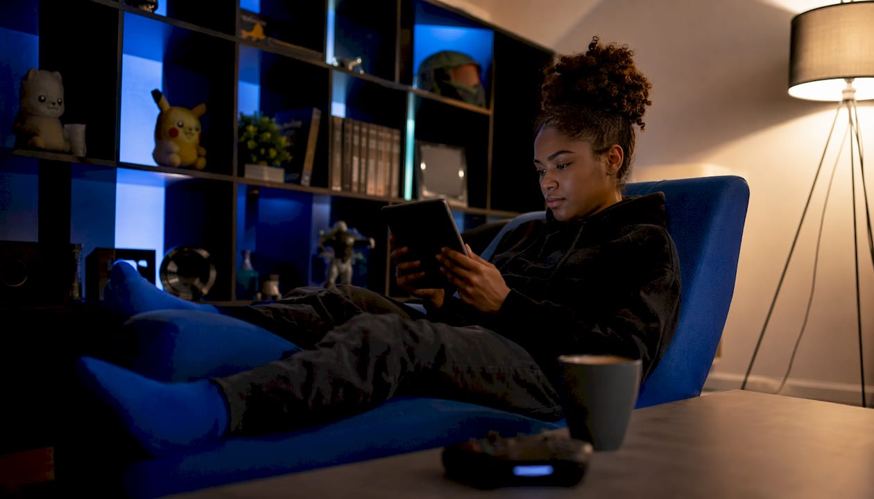 Woman browsing multiplayer games on tablet at home
