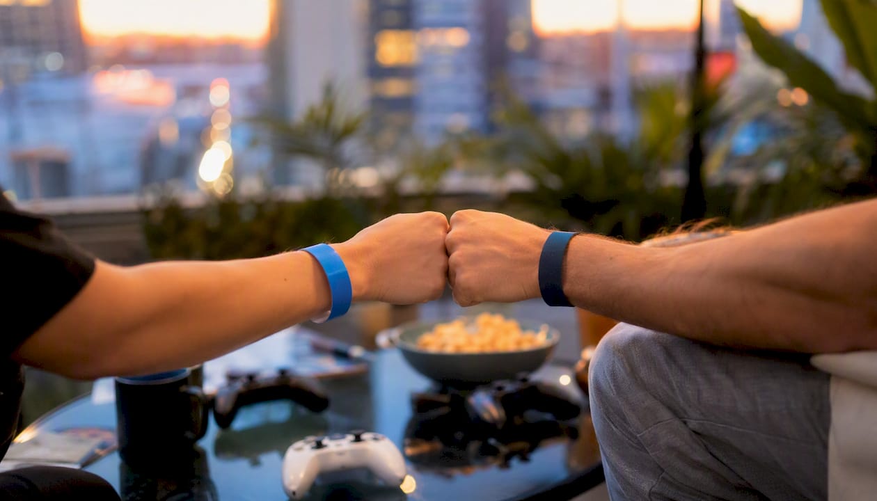 Hands fist bumping over game controllers