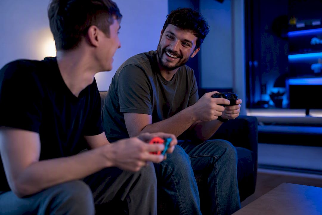 Hands holding Switch and Xbox controllers close together