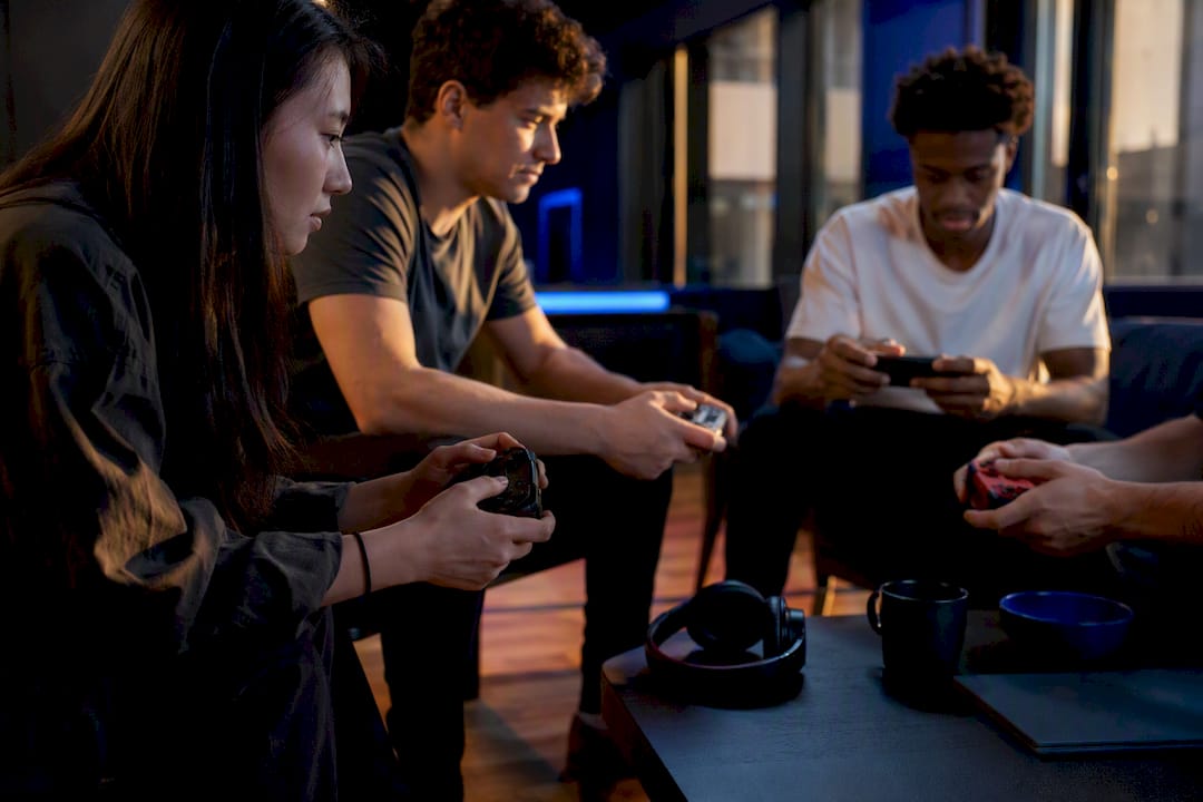 Hands playing with cross-platform game controllers and smartphones