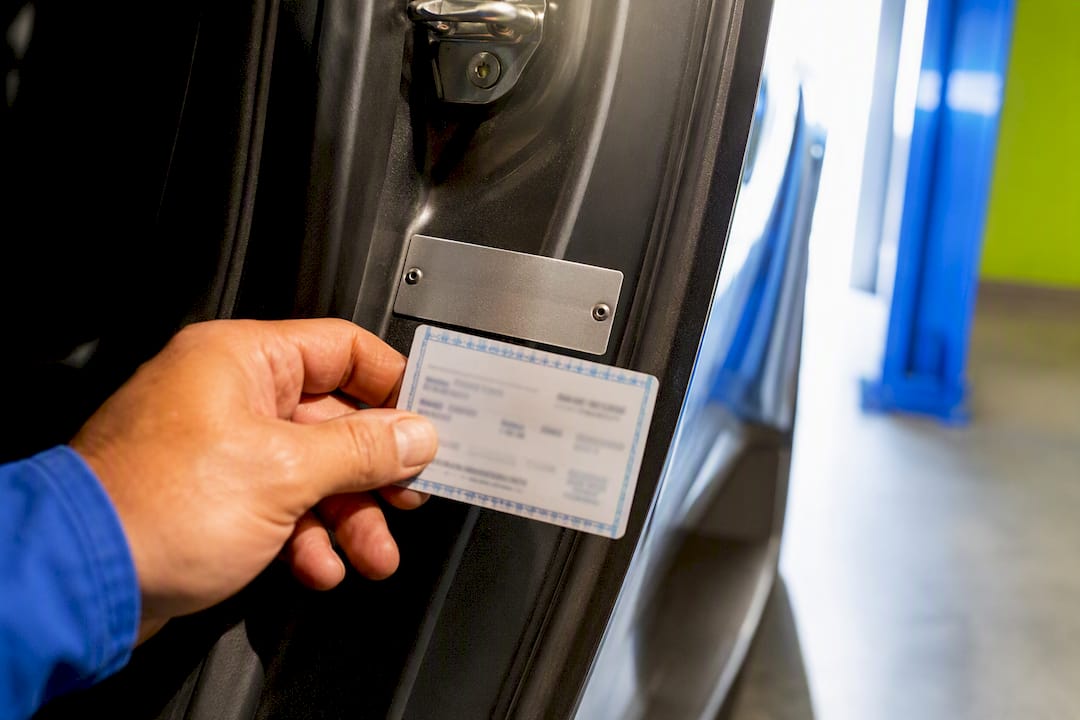Hand comparing VIN plate with vehicle card