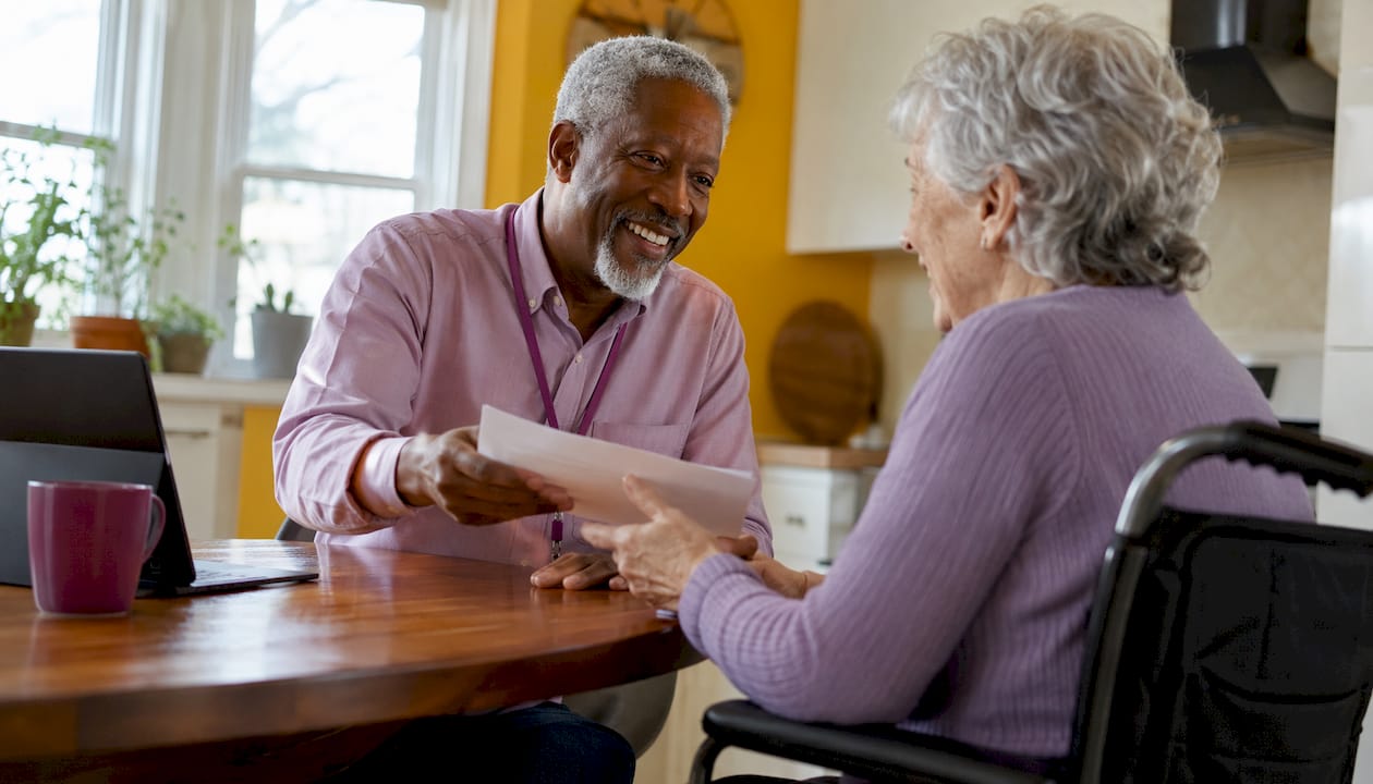 Healthcare worker assisting senior client at home