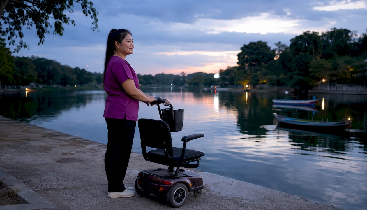 Caregiver's hands on mobility scooter handle outdoors